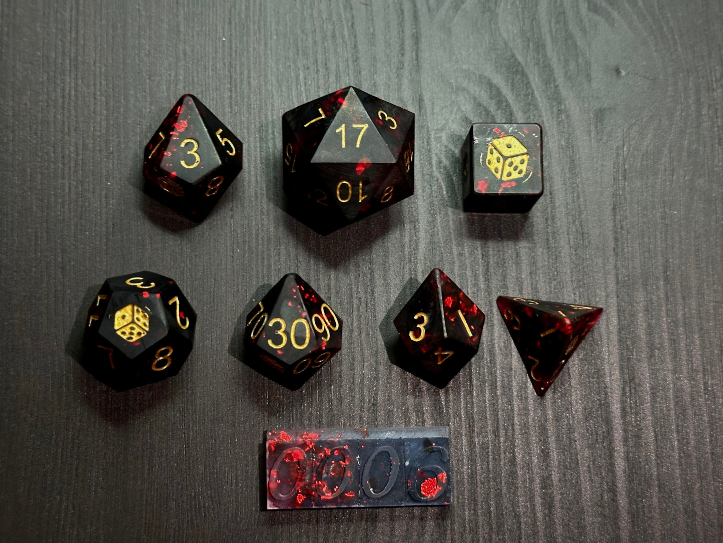 Czarno-czerwony zestaw kostek RPG z żywicy na stole, unikatowe kostki do DnD, złote cyfry