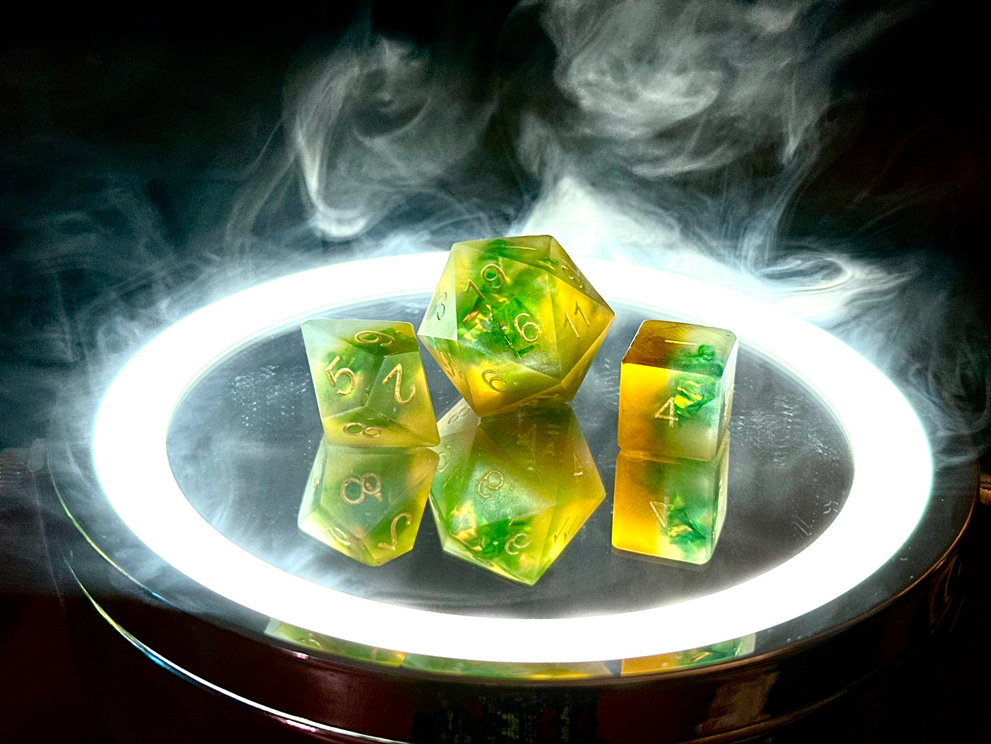 Pomarańczowo-zielone żywiczne kostki RPG na podświetlonym tle z dymem, kostki do DnD.