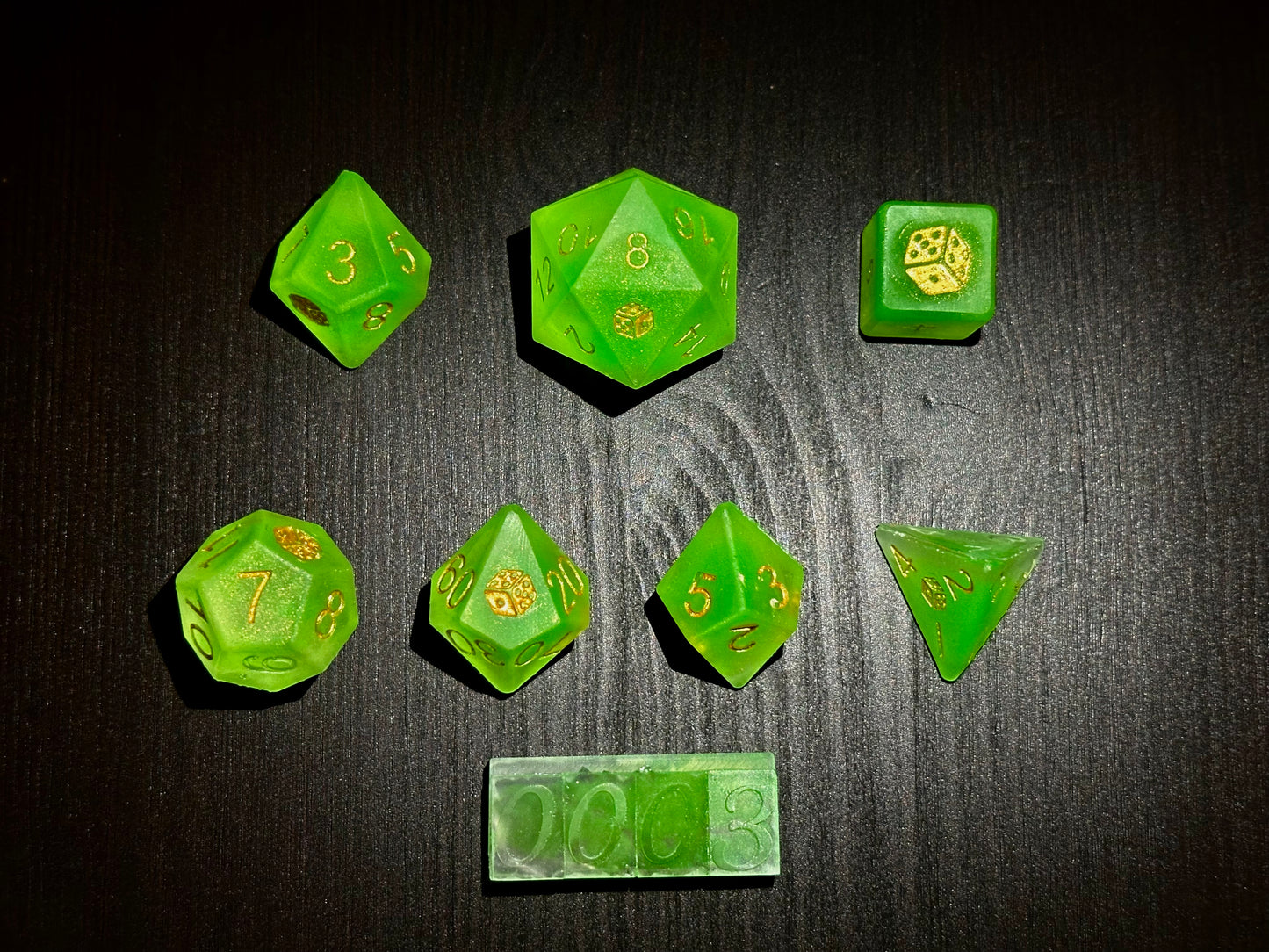 Neonowo zielone kostki RPG z żywicy z złotymi cyframi na czarnym stole, handmade zestaw.