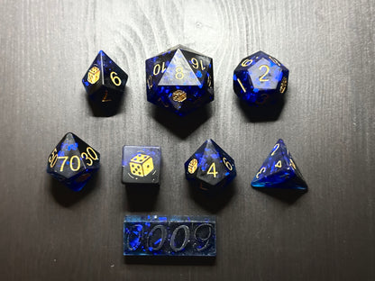 Niebiesko-czarne kostki RPG z żywicy z złotymi cyframi na czarnym stole, zestaw do DnD.
