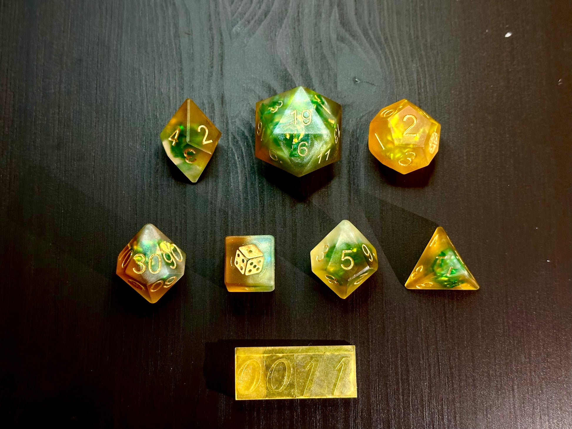 Pomarańczowo-zielone kostki RPG z żywicy na stole, ręcznie robione zestaw do DnD.