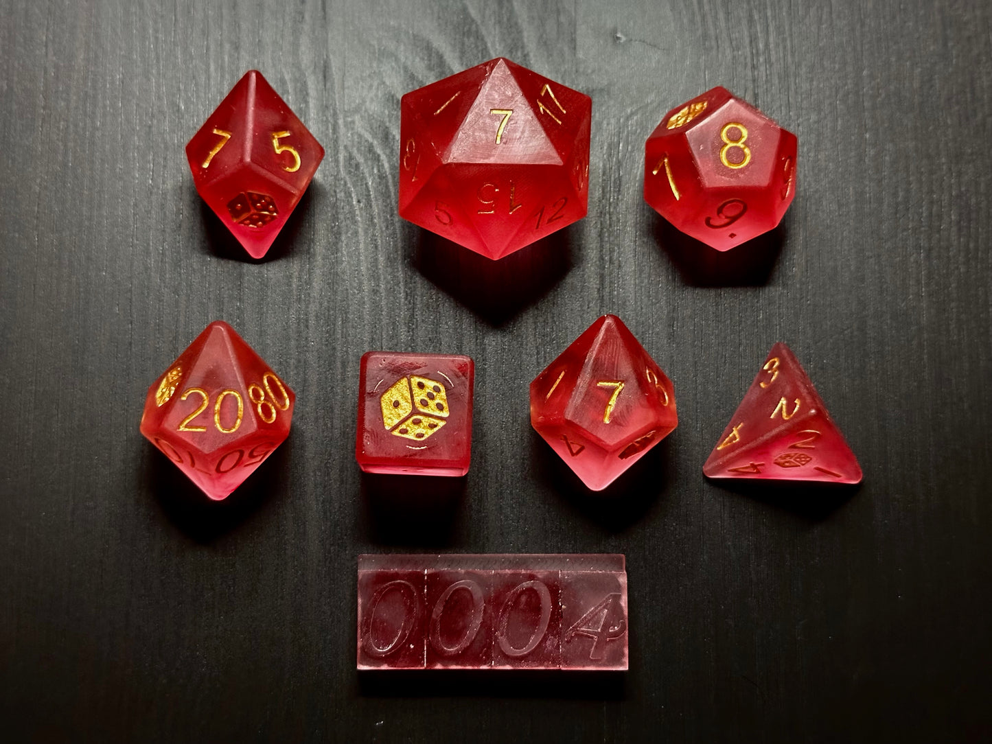Pudrowy zestaw ręcznie robionych różowych kostek RPG z żywicy na czarnym stole