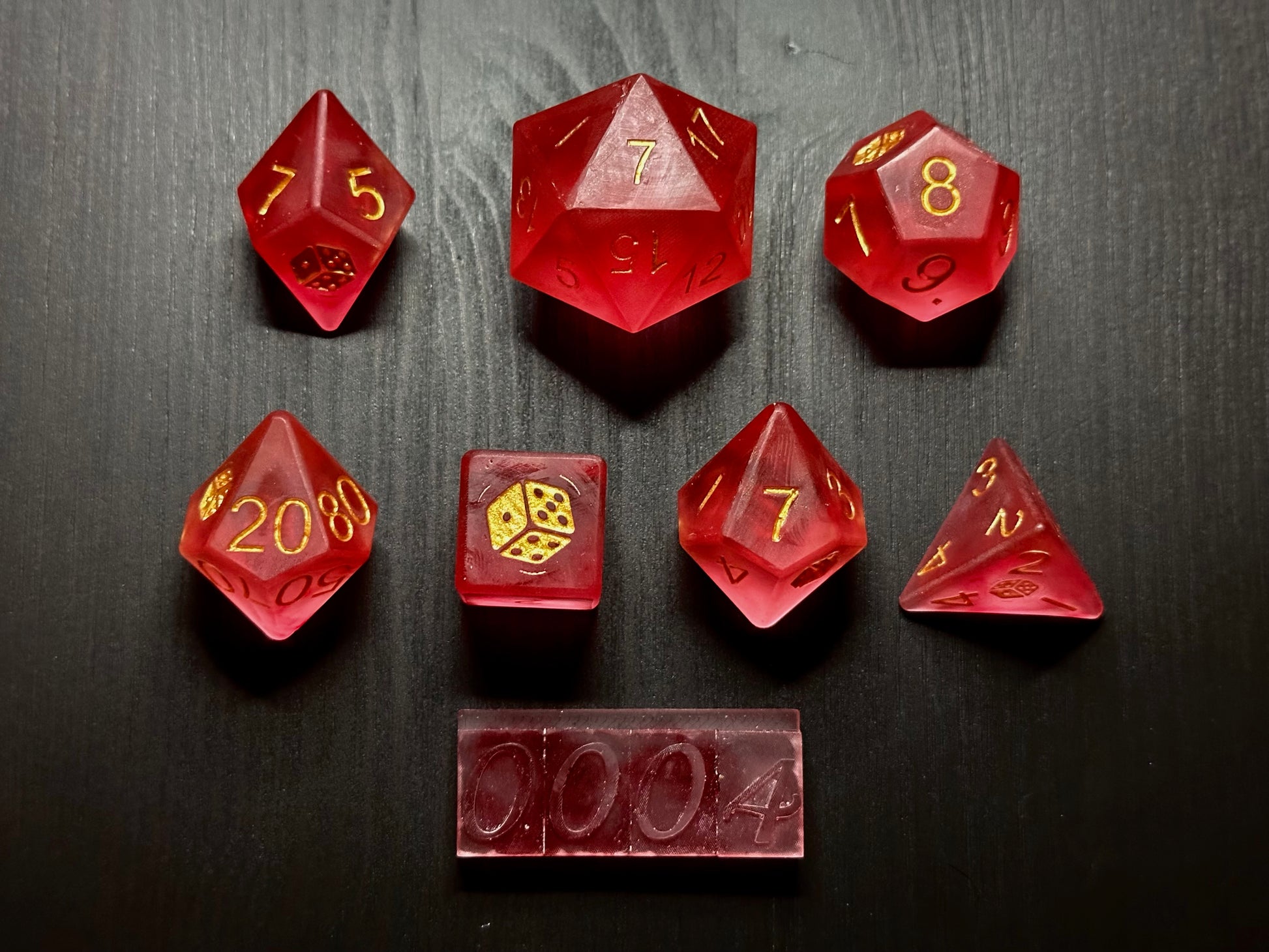 Pudrowy zestaw ręcznie robionych różowych kostek RPG z żywicy na czarnym stole
